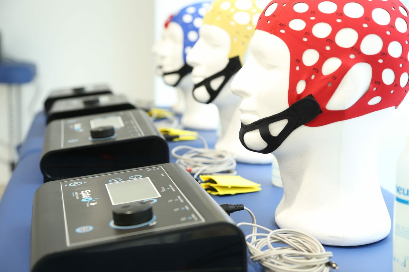 Шапочки tDCS трёх размеров рядом с аппаратом EPTE® Bipolar System