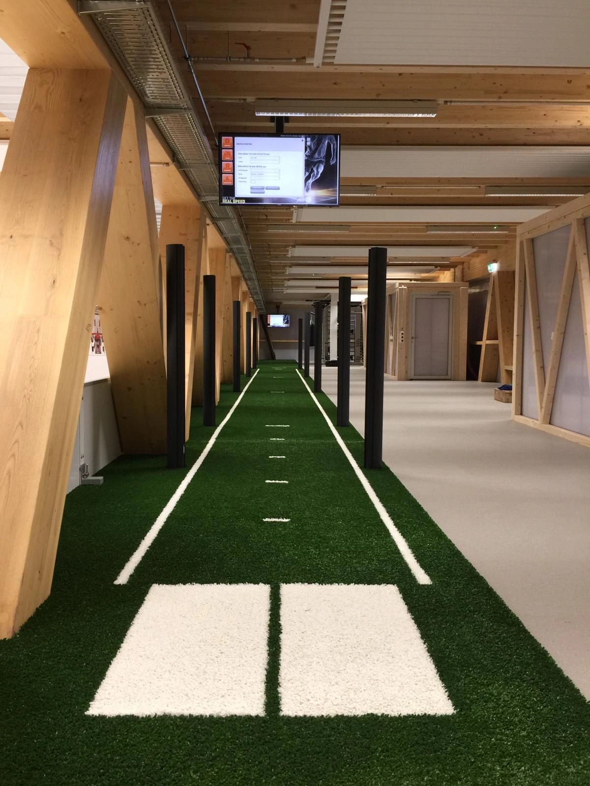 Стартовые пластины дорожки SpeedTrack на газоне и чёрные стойки лазерных барьеров