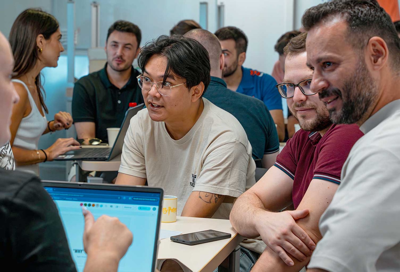 Сотрудники KINVENT обсуждают проект за ноутбуками в офисе