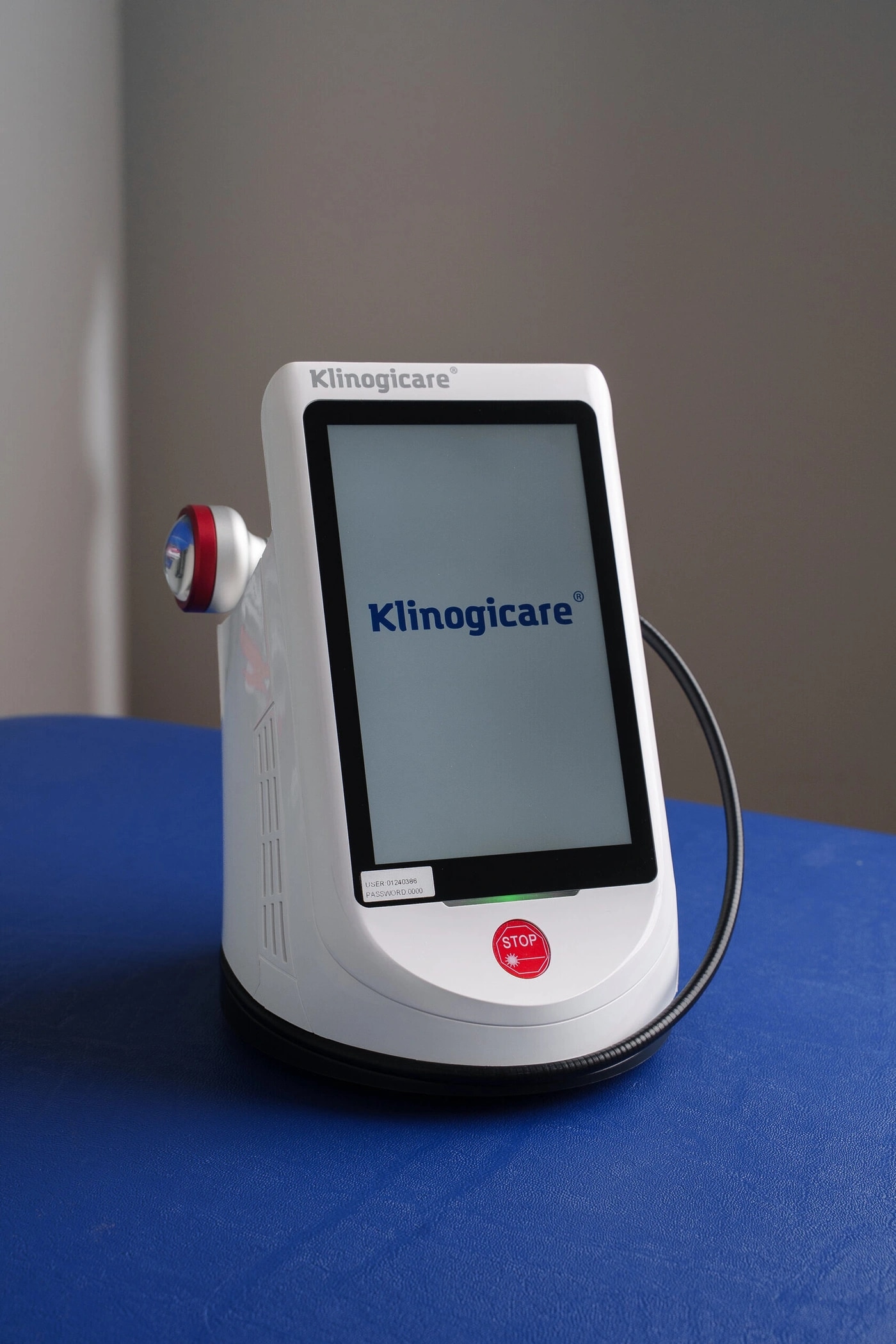 Beam Ultra 30W на синей кушетке, на экране заставка Klinogicare, аппликатор закреплён на корпусе