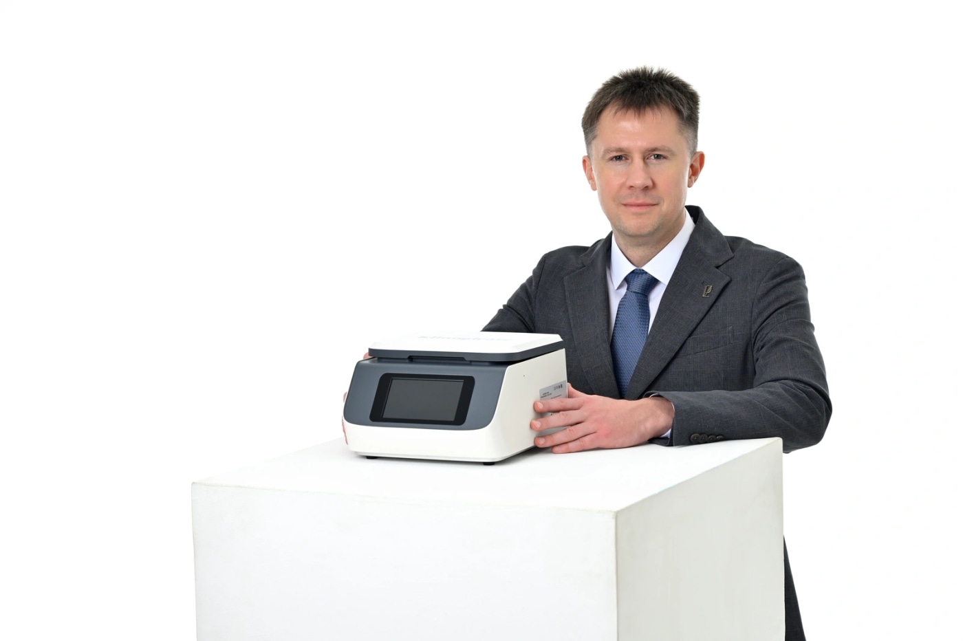 Специалист держит анализатор Klinogicare StarLab Hormones & Proteins на белом подиуме